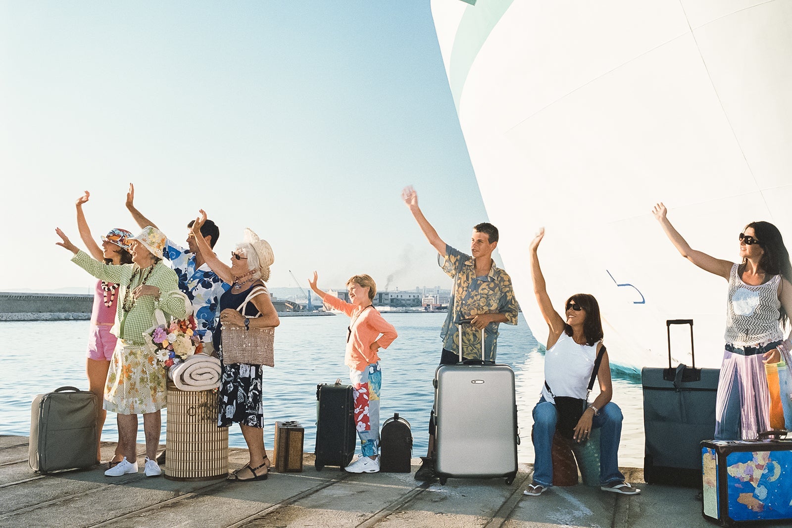 Group of people by ship waving goodbye