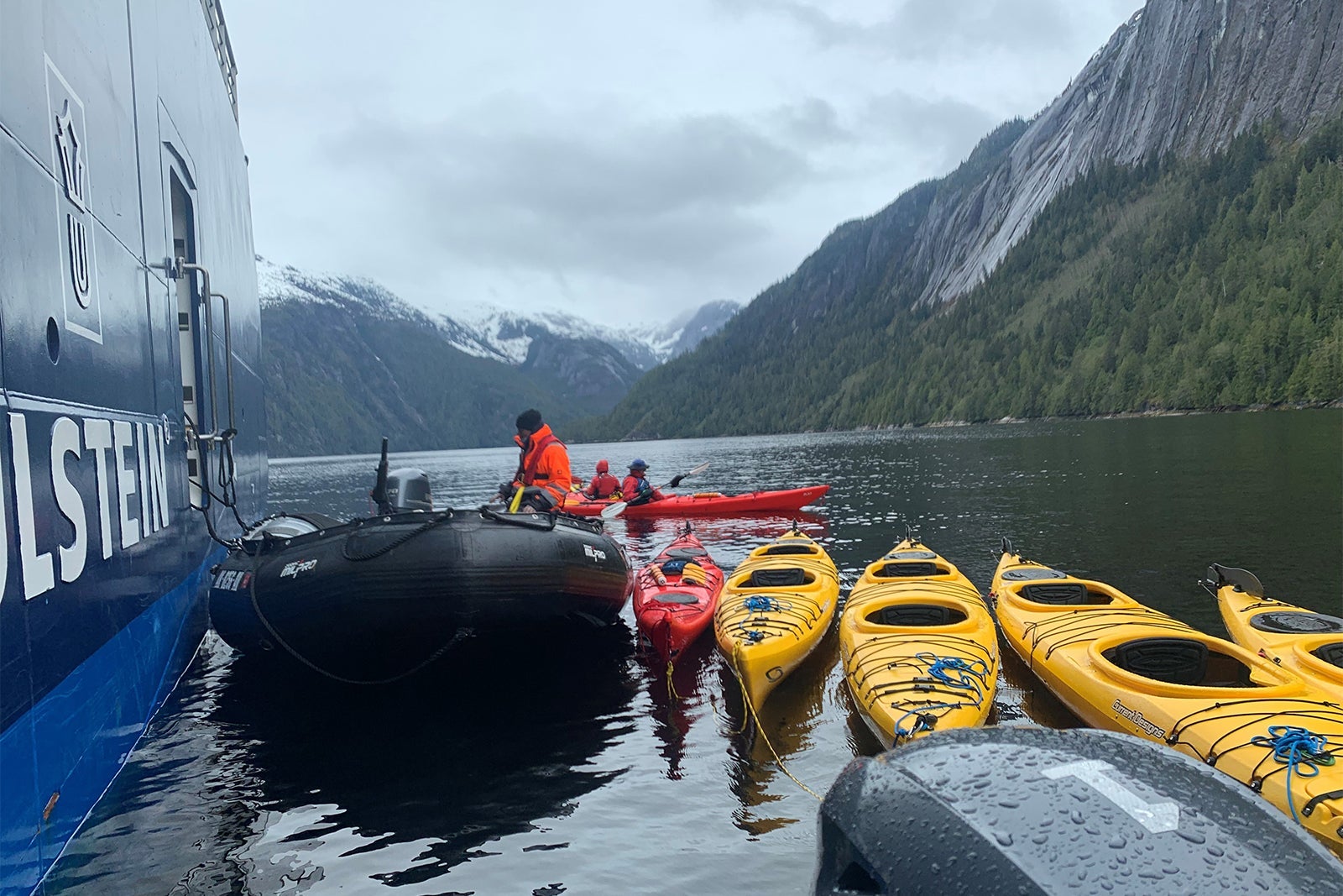 Fleet of kayaks and zodiacs tied up to Ocean Victory cruise ship