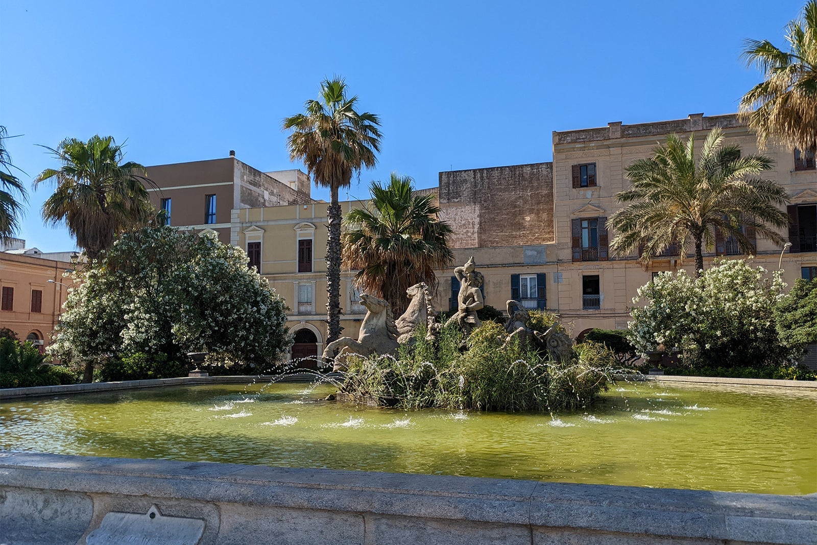 Fountain amid palm trees and greenery in Trapani, Italy