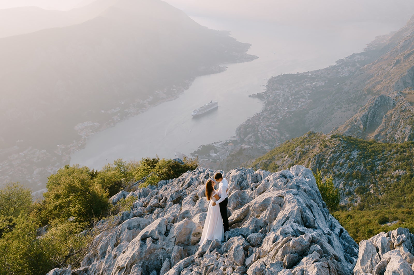 bride and groom on mountain overlooking cruise ship