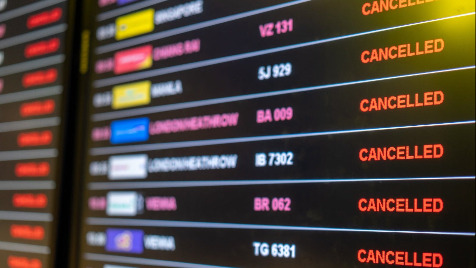 Airport departures board showing a number of flights boarding, or on their cancelled .