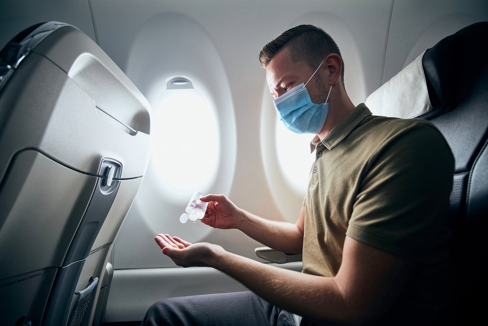 Man uses hand sanitizer on plane