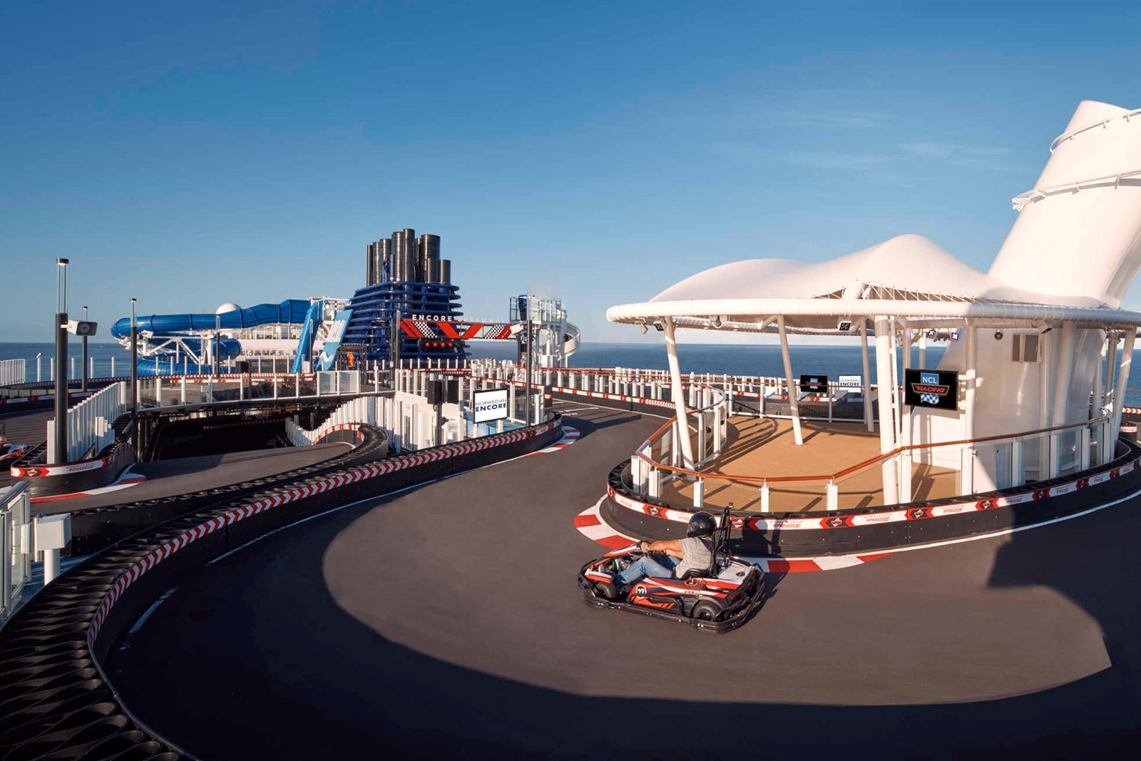 A go-kart zooms around an outdoor race track on top of a cruise ship