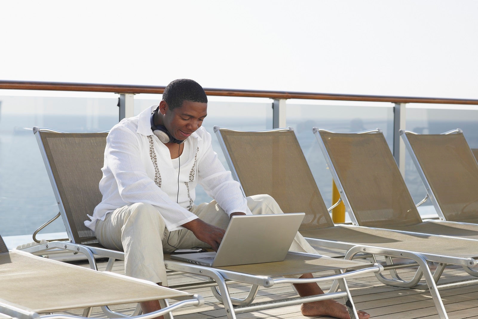 man using laptop on ship deck