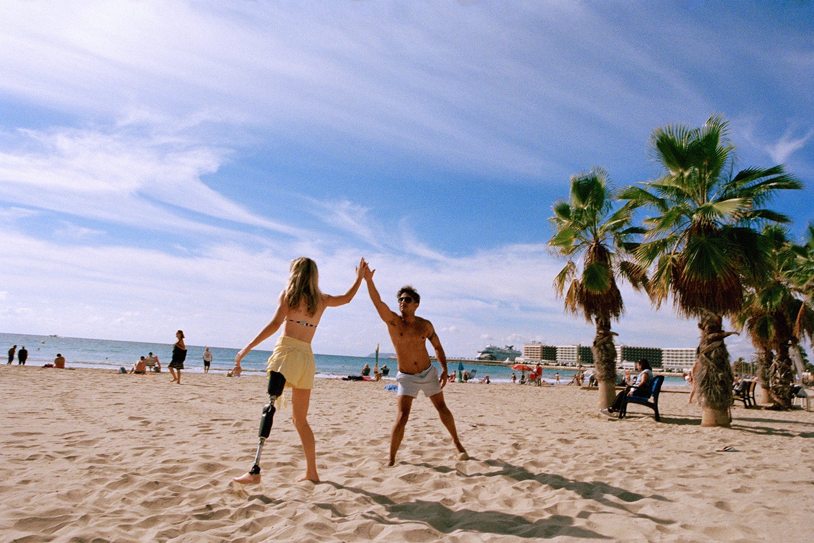 man and woman high-fiving on the beach