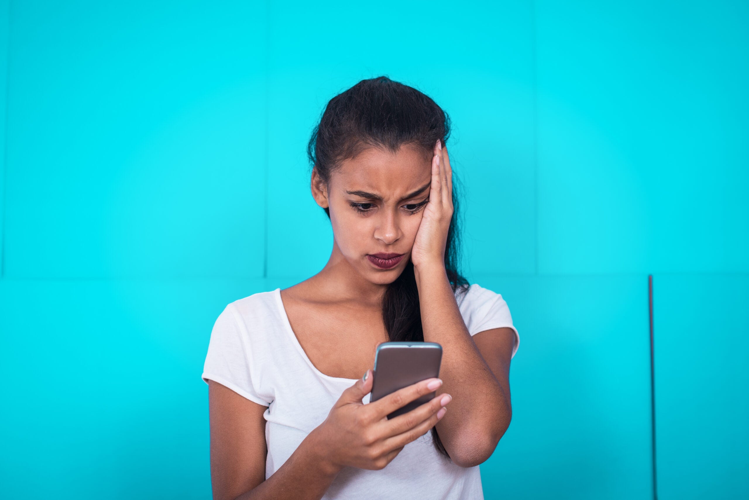 Disappointed person looking at a cell phone