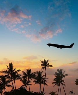Plane takes off in sunset