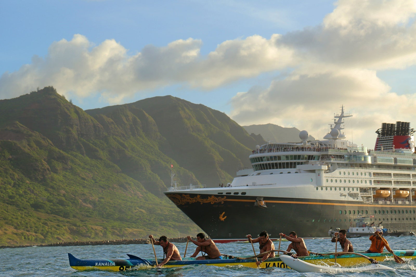 Kayakers row past a Disney cruise ship anchored near the coast of Kiwiliwili, Hawaii