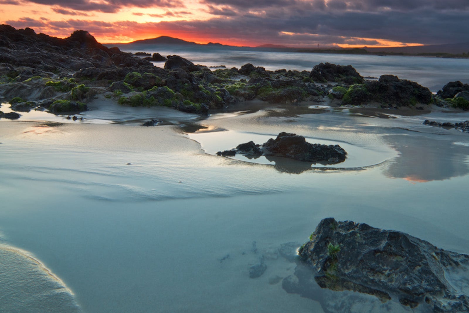 beach at sunset with rock formations in water