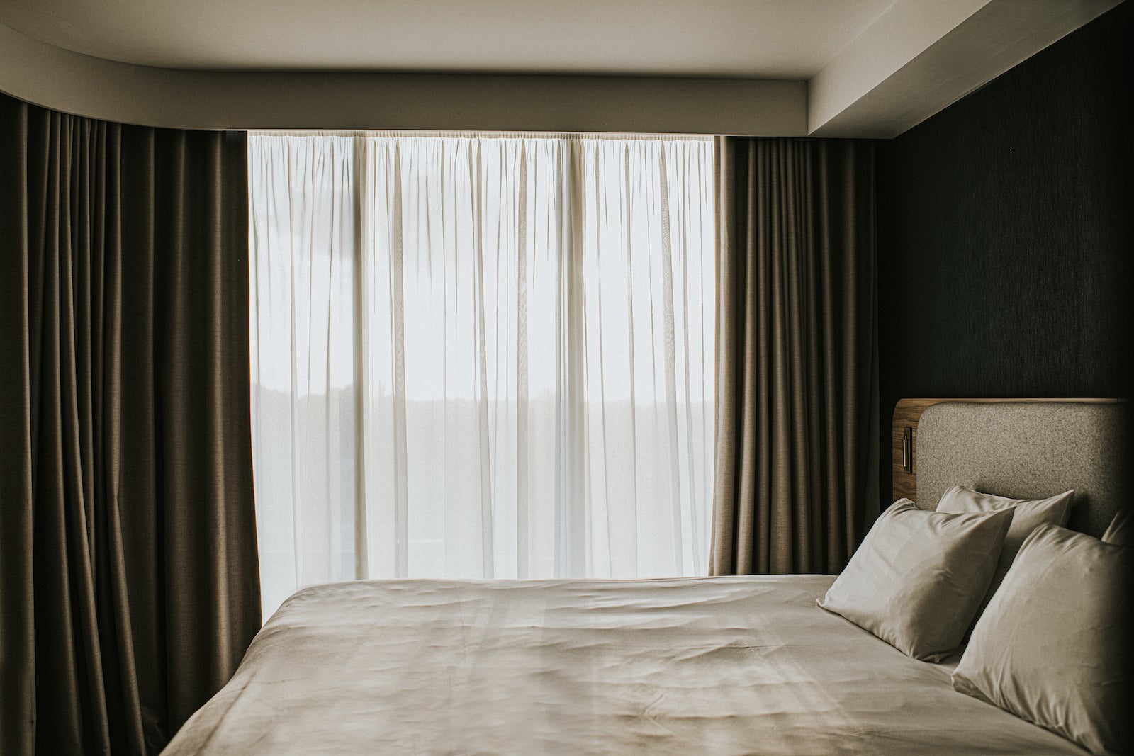 a hotel room with the curtains drawn during the day