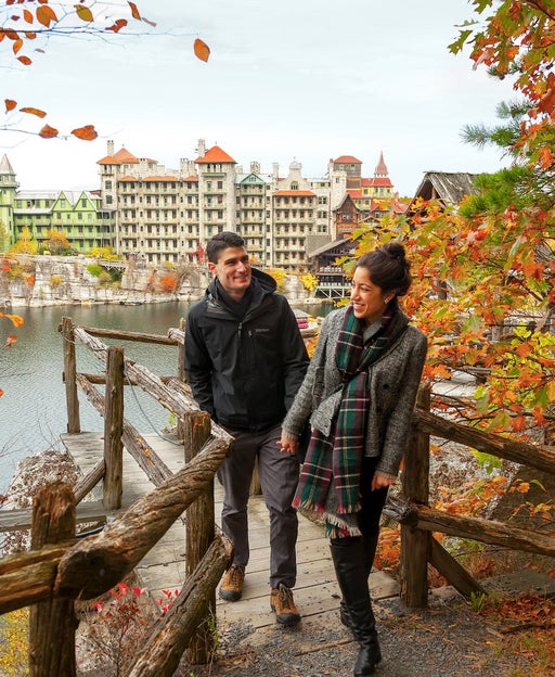 couple walking up steps with castle-like resort in the background