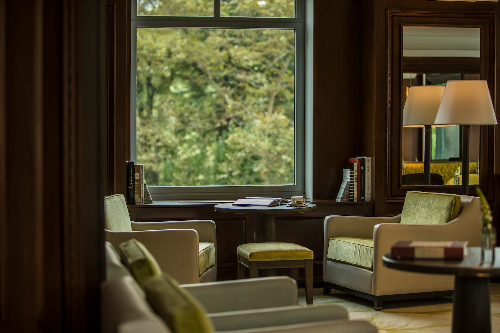 green velvet armchairs in a dark wooden room