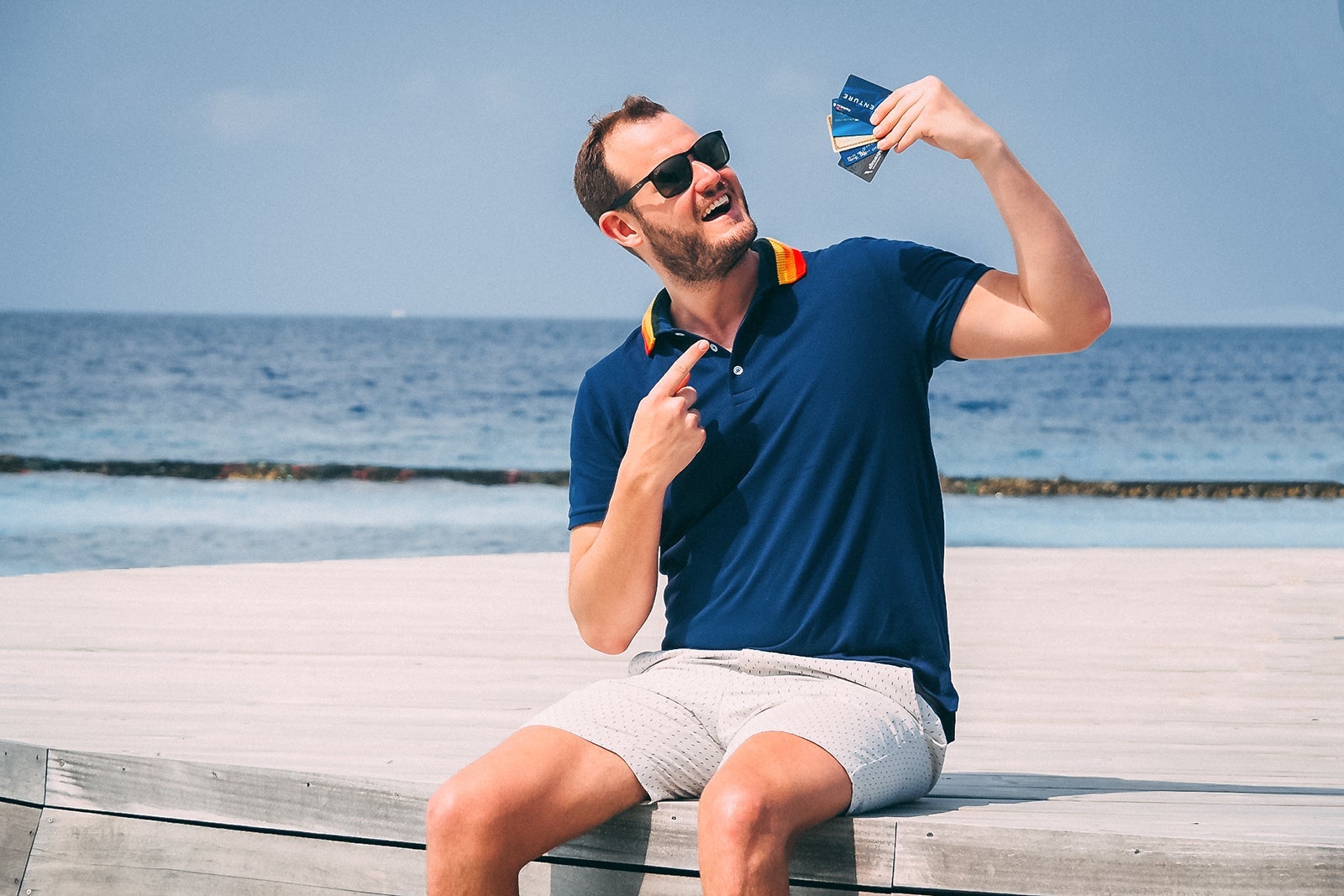 A man points at a handful of credit cards