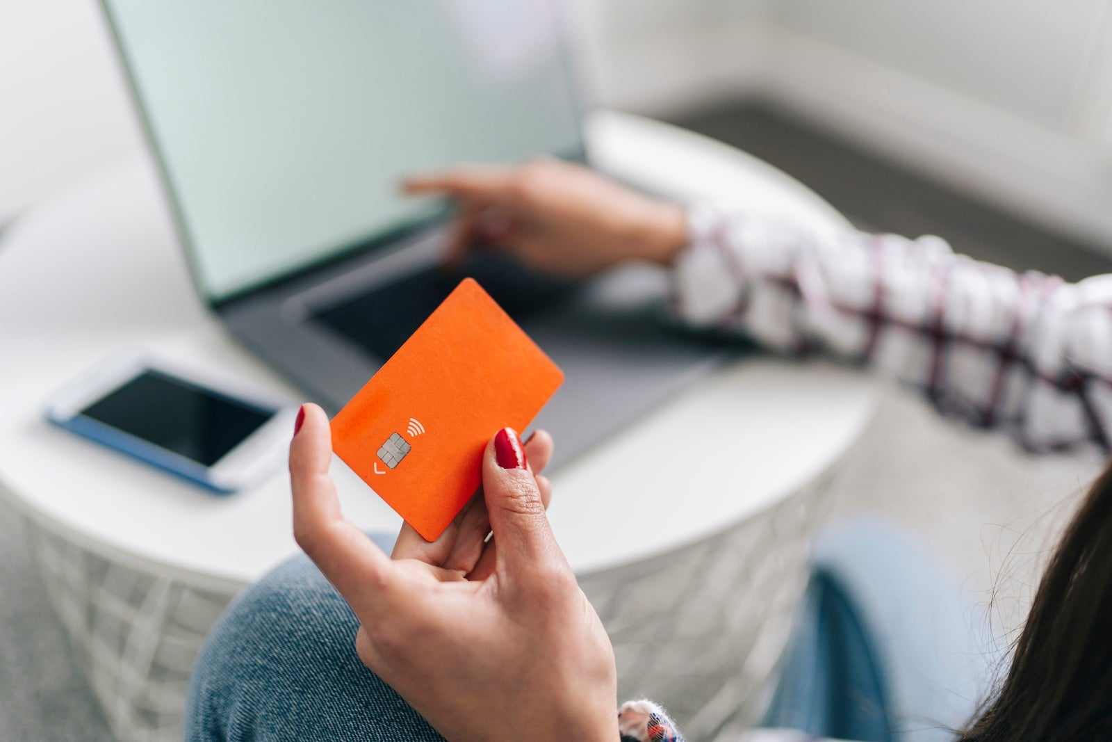 Woman with credit card doing online shopping through laptop at home