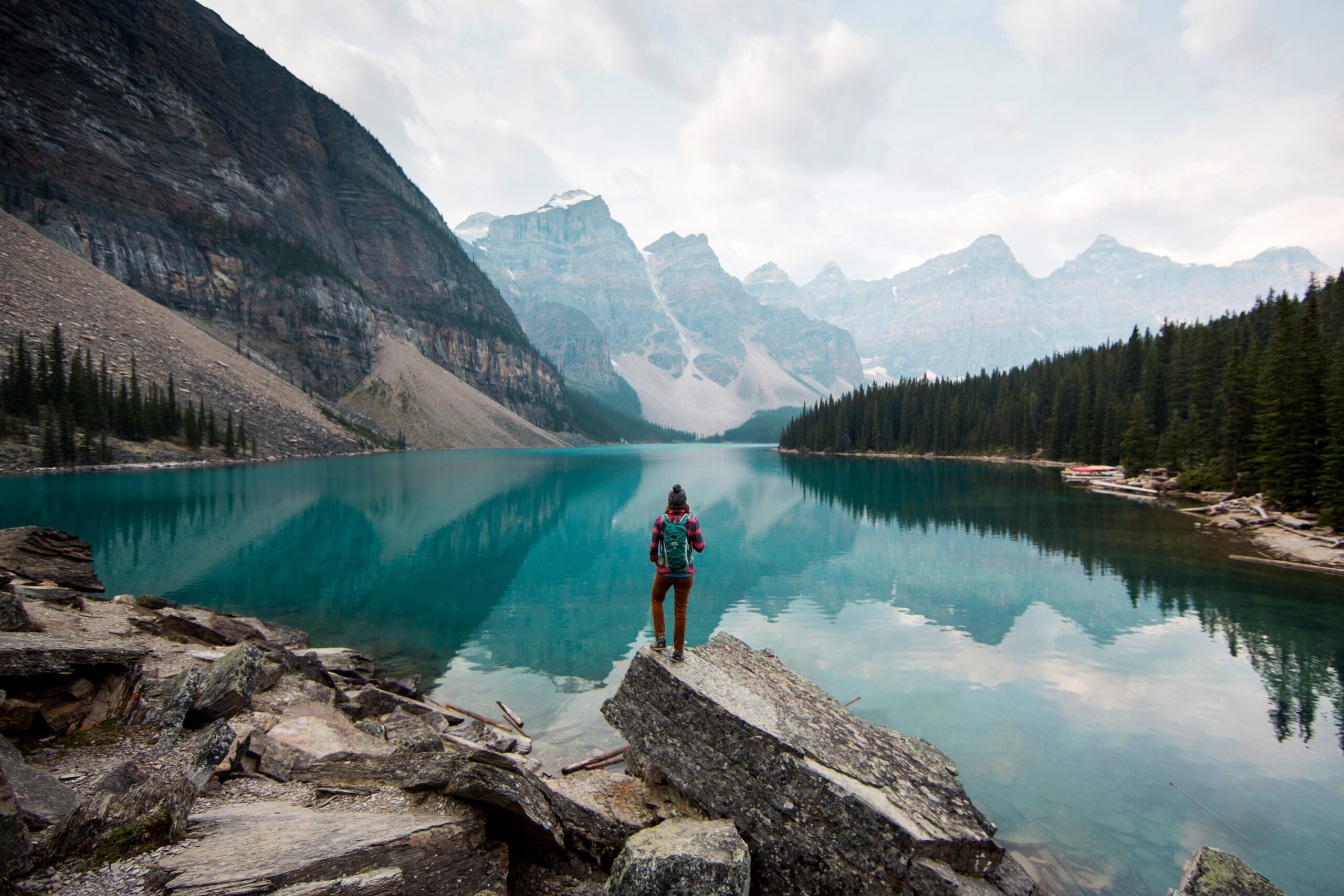 A hiker stopped at Moraine Lake overlooking the water.