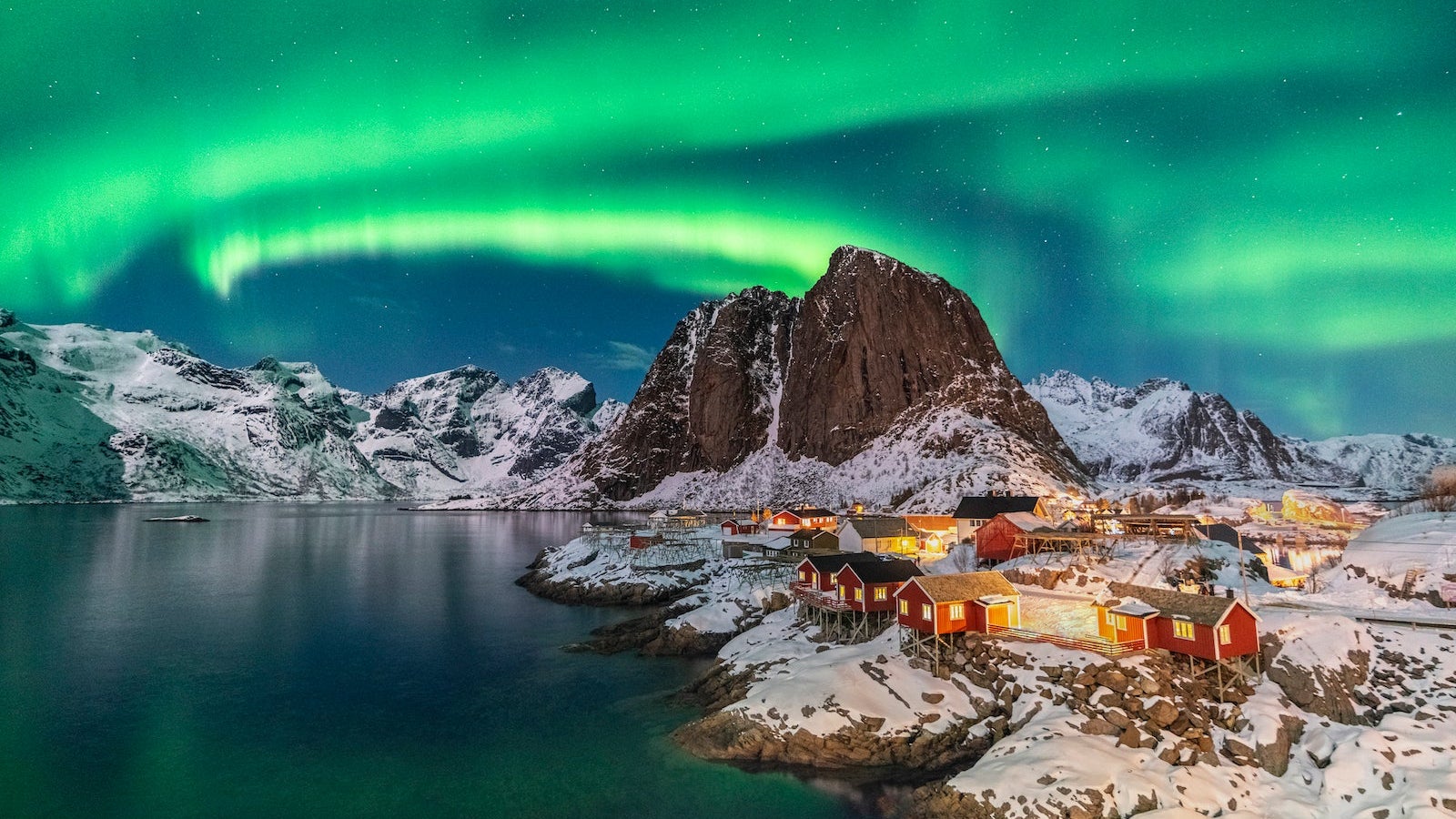 Northern lights above Festhelltinden peak and Hamnoy, Lofoten Islands.