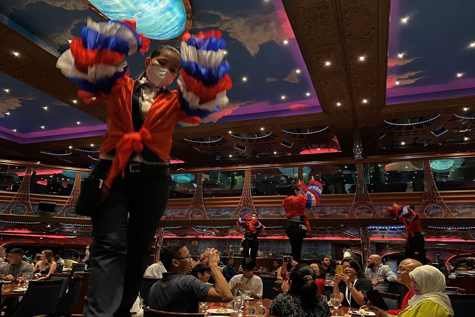 Members of Carnival Conquest's waitstaff dance in the dining room on formal night.