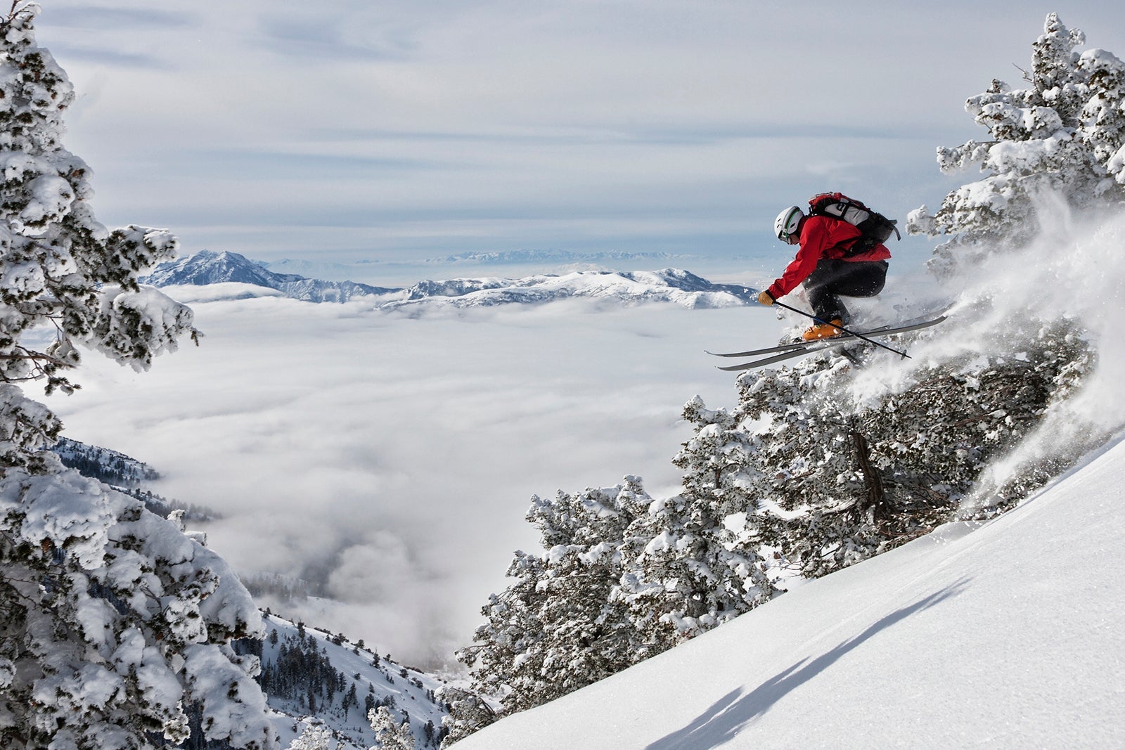 A backcountry skier jumping off a ledge