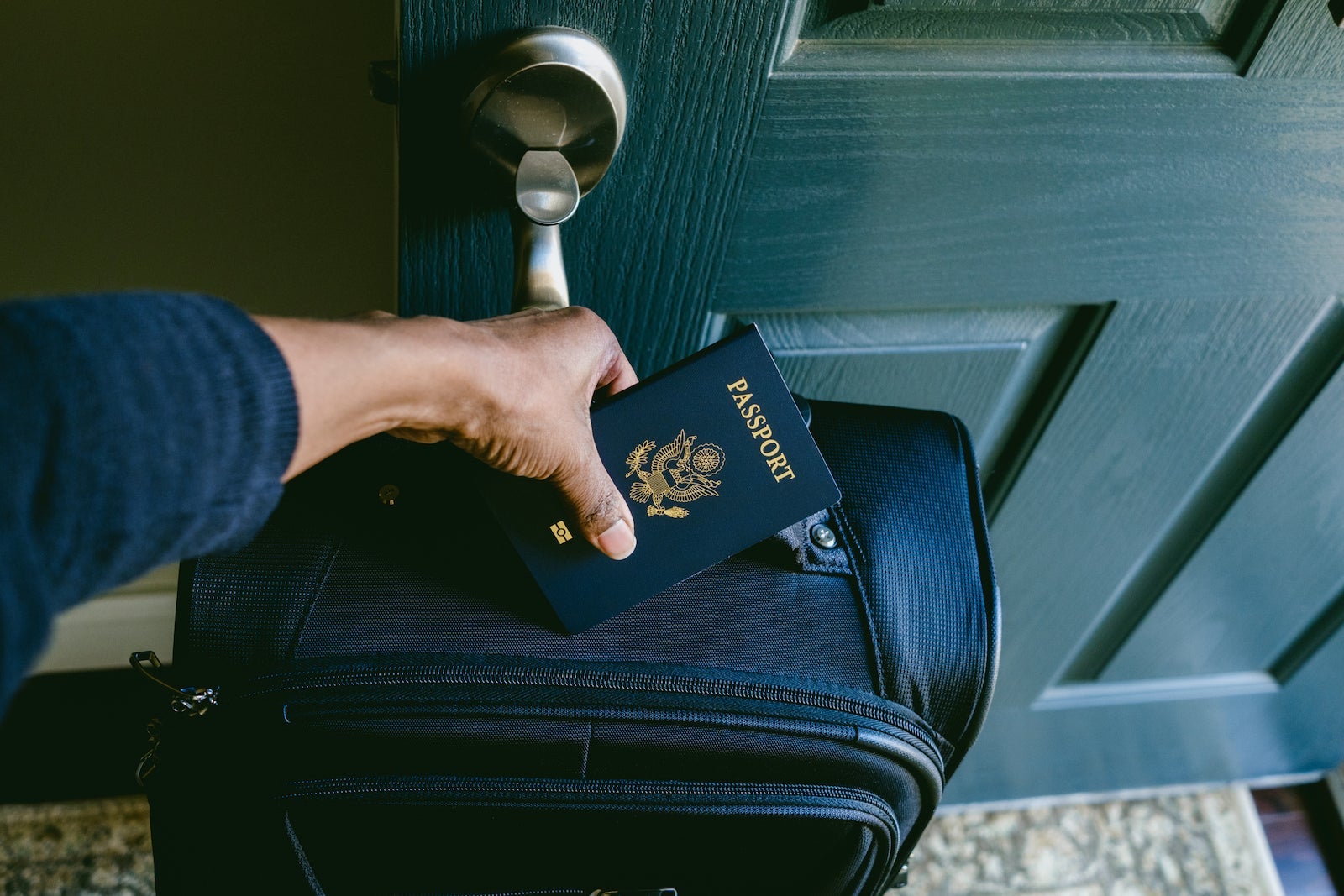 hand holding passport with luggage
