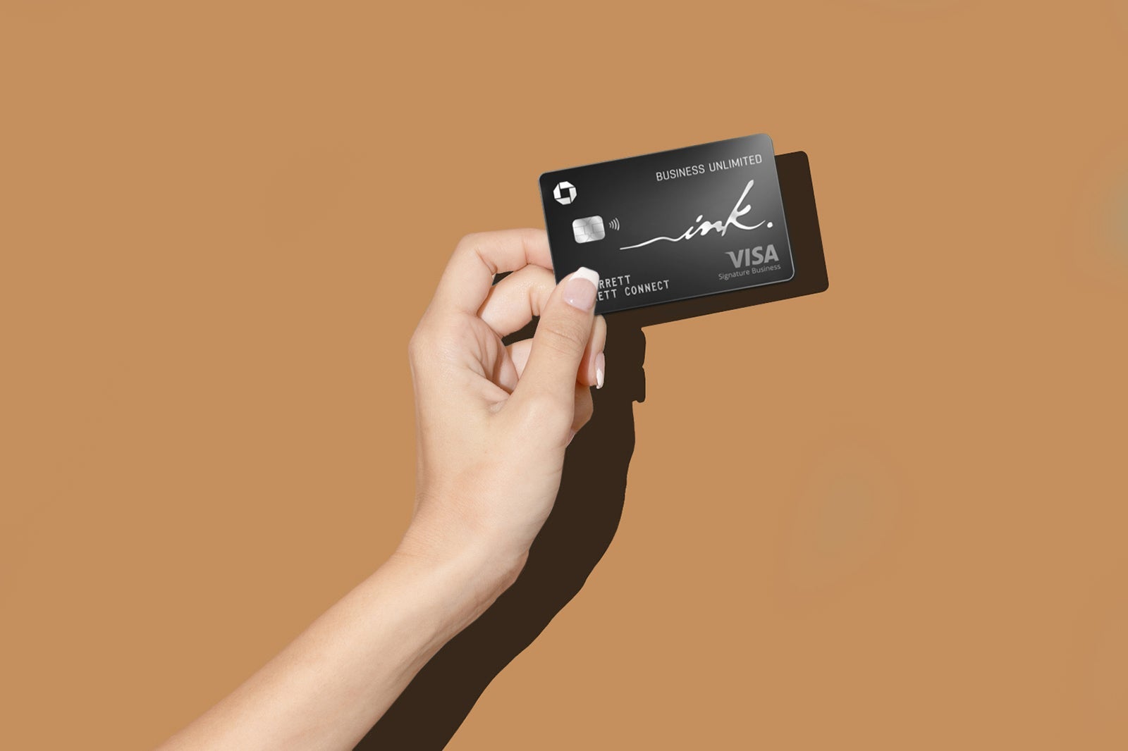 a hand holds a credit card