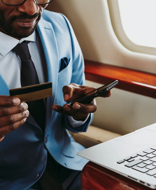 a man makes a credit card payment on his laptop during a flight