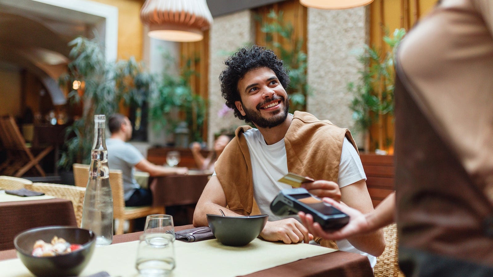 Young Man Paying for Meal at Restaurant