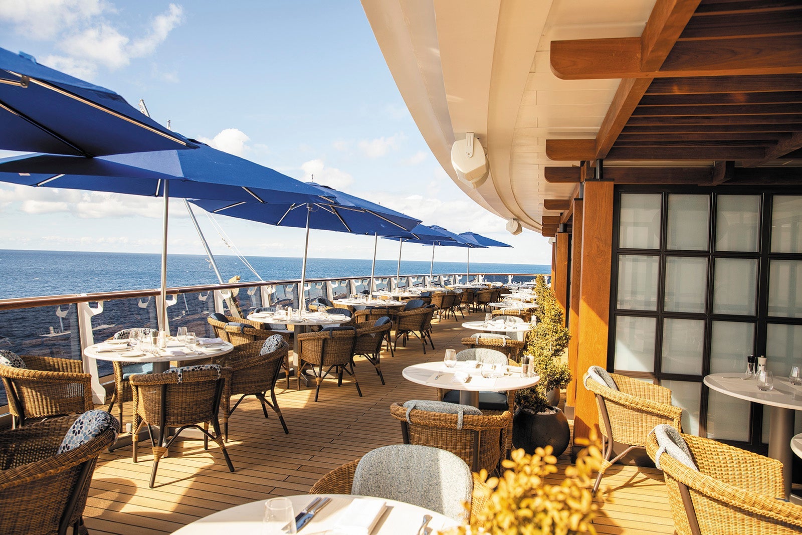 A cruise ship sun deck area with umbrellas and tables