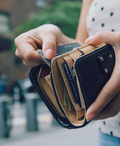 An unseen person holds a wallet with many credit cards