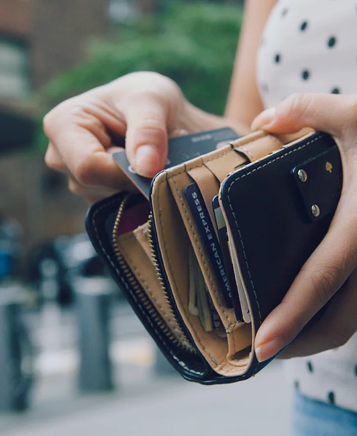 An unseen person holds a wallet with many credit cards