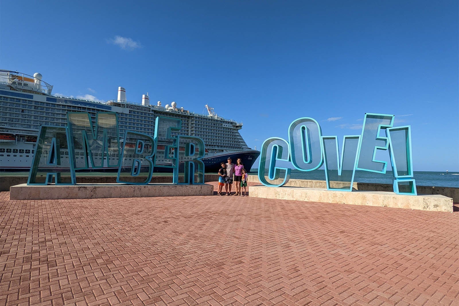 Family by Amber Cove sign in front of Carnival cruise ship