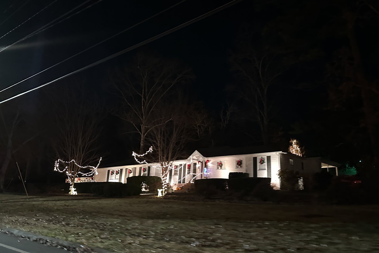 Christmas lights on a white home in a small town