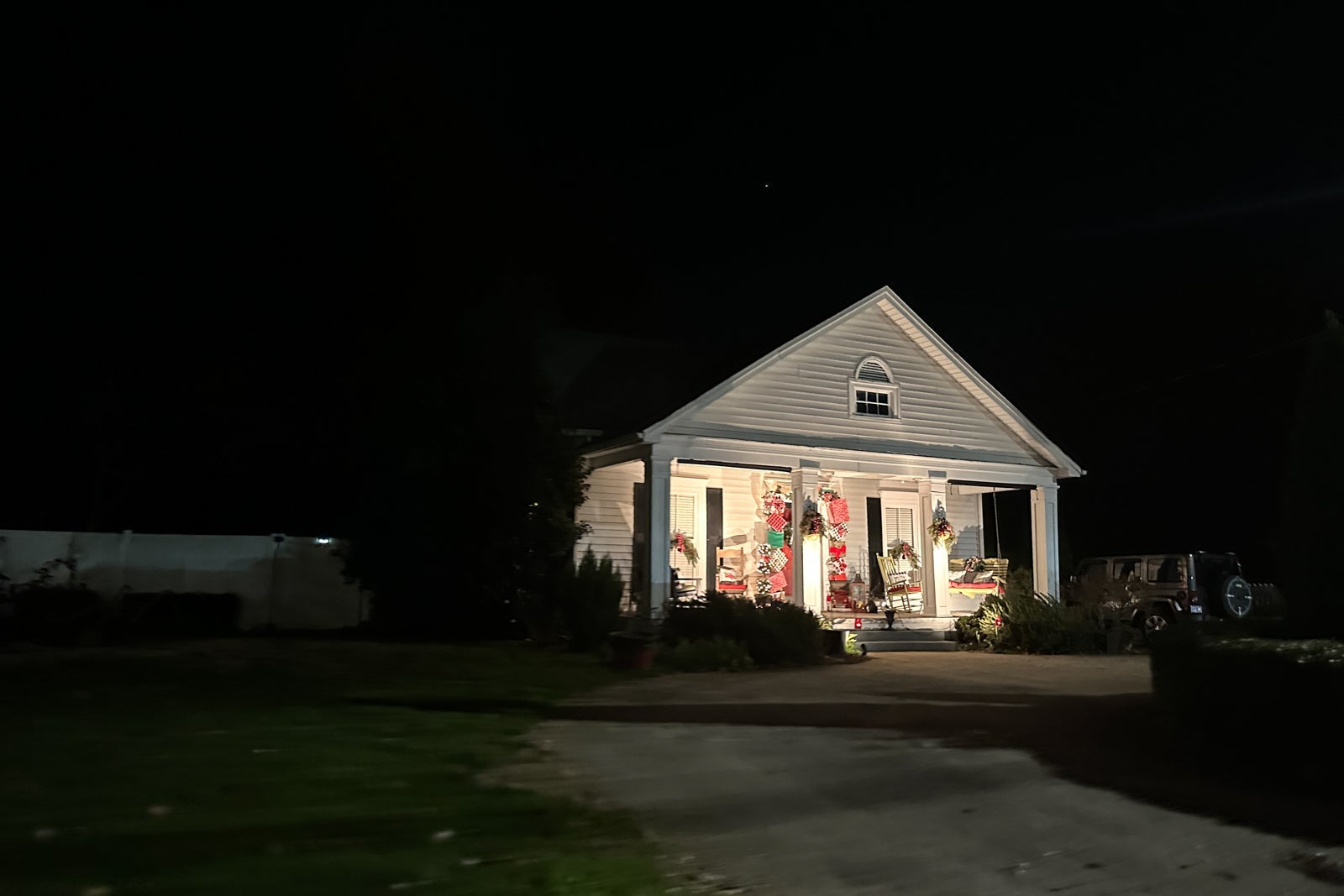 Christmas lights on a white home in a small town