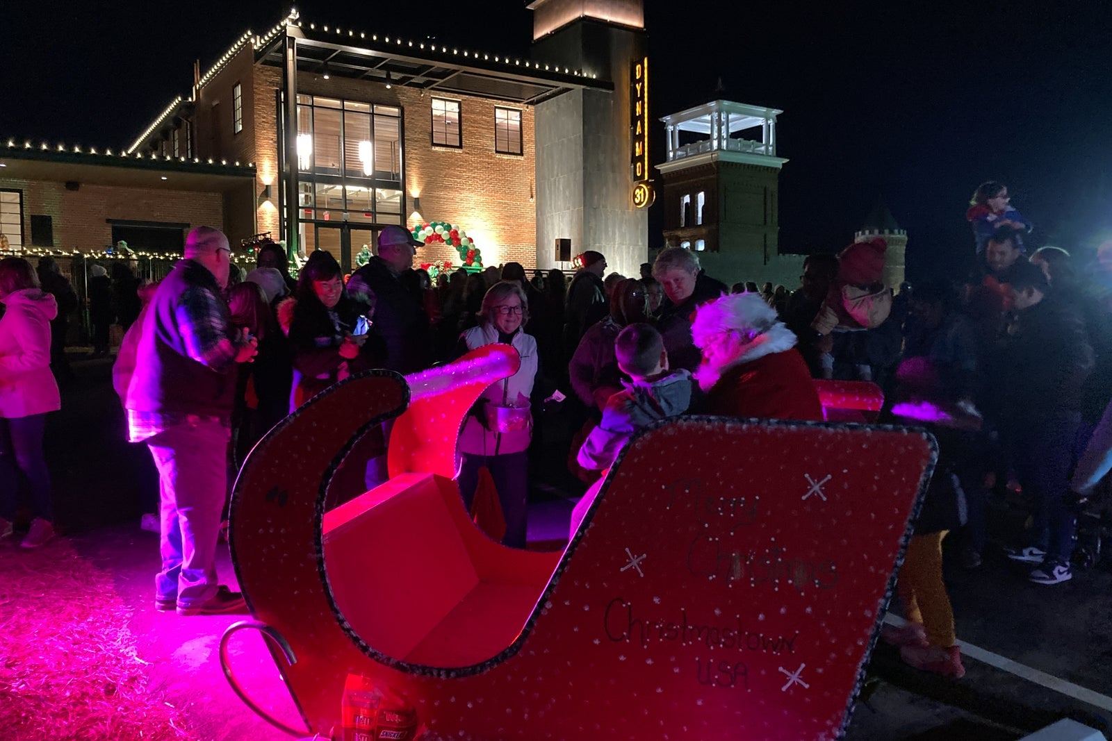 Santa sits in a sleigh while talking to children