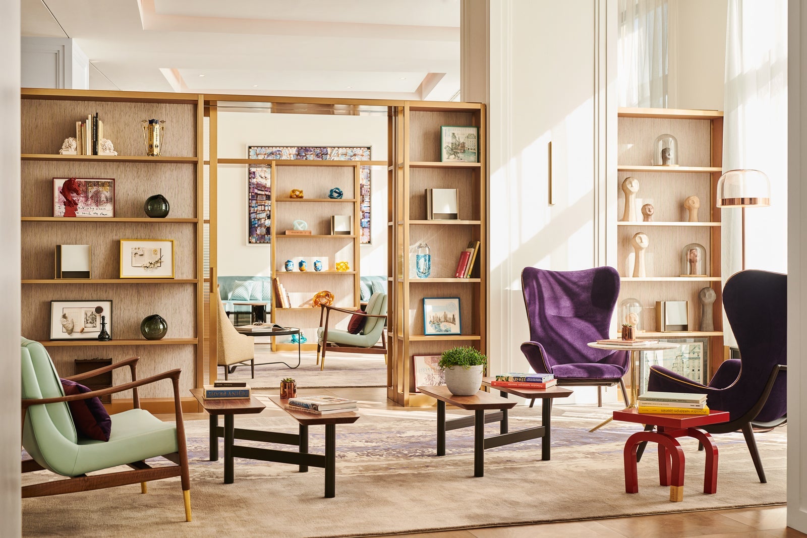 stylish hotel lobby with colorful chairs and bookshelves
