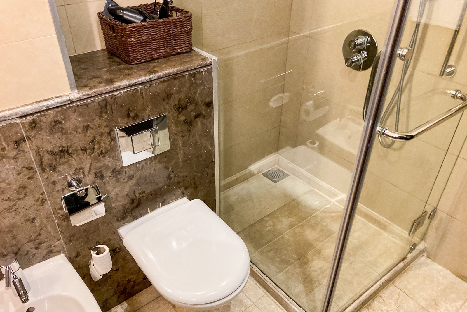 the toilet and glass shower box t in a hotel bathroom