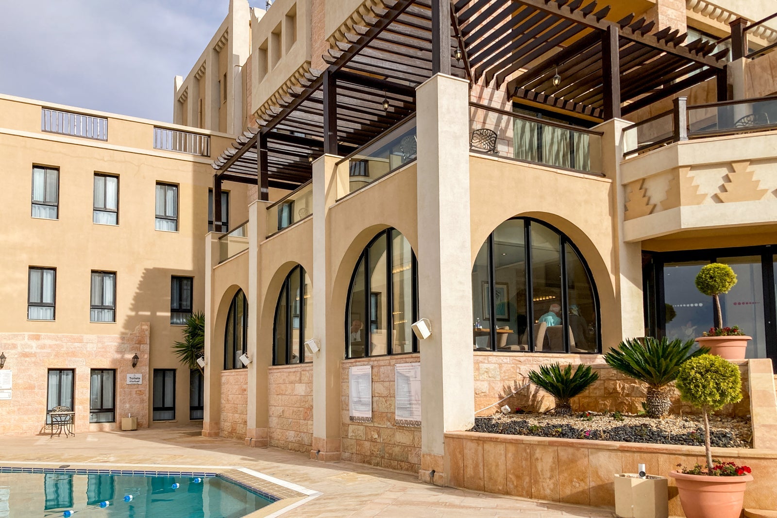 looking up at a hotel's restaurant area from the swimming pool
