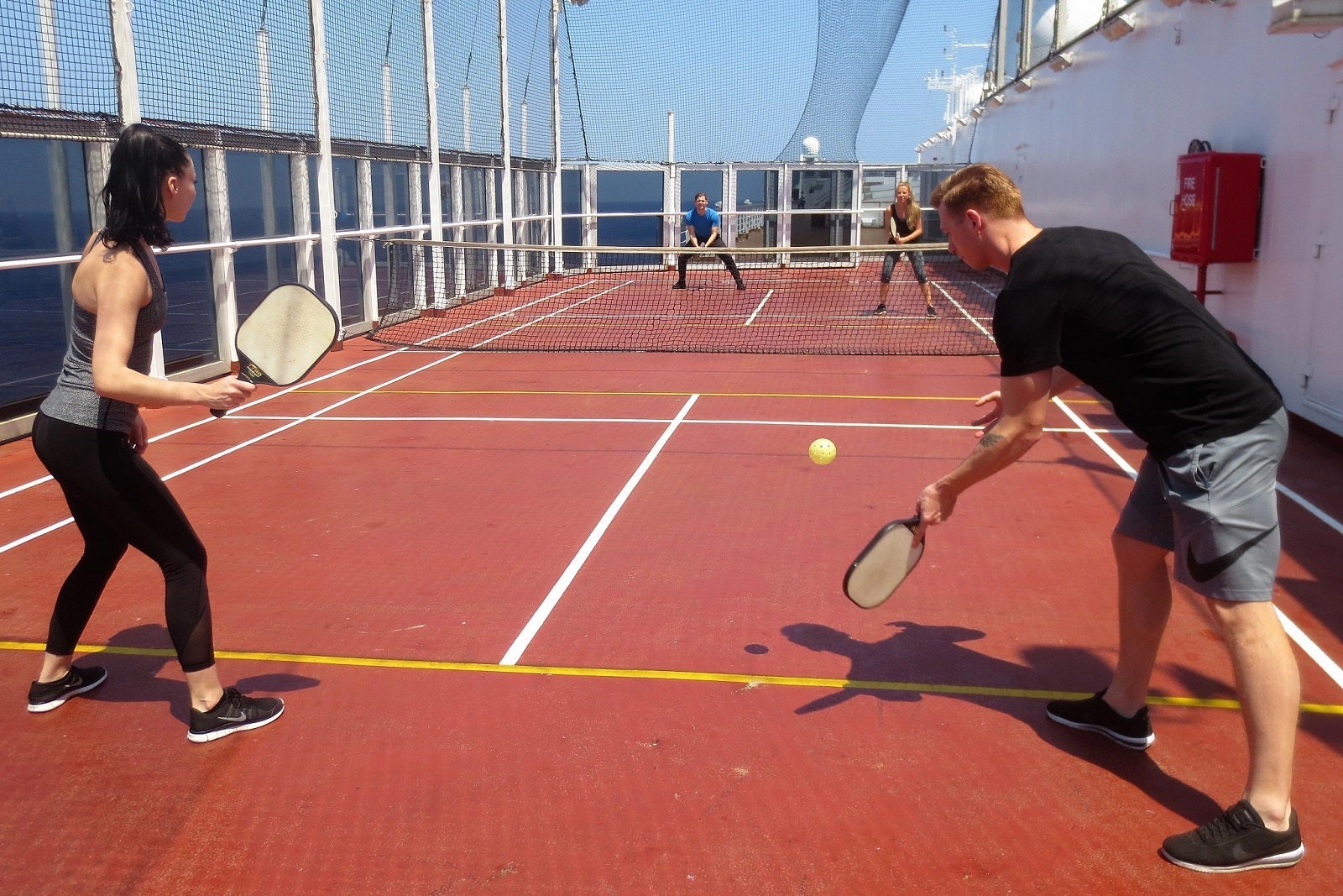 Four guests playing pickleball on a cruise ship