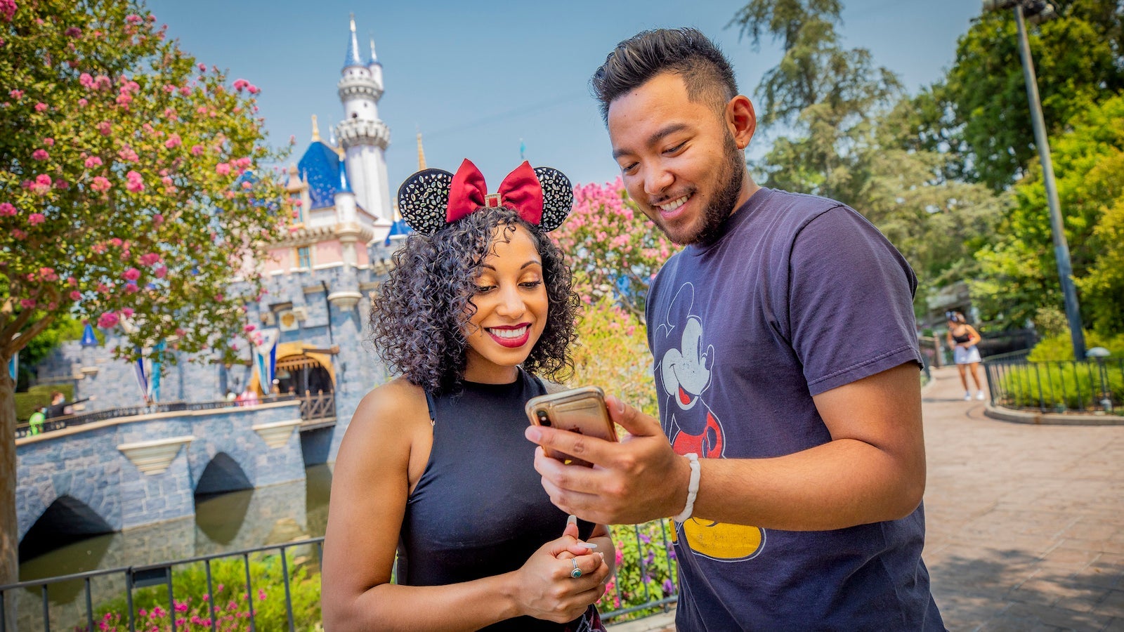couple looking at cellphone at Disney park