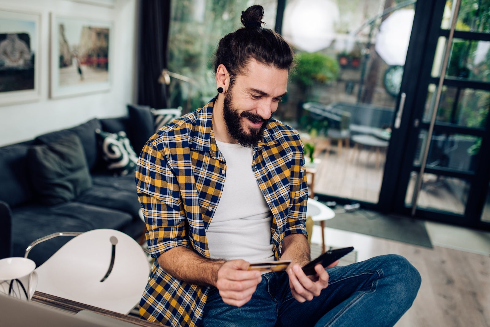 a young man reads about his credit card benefits while sitting at home
