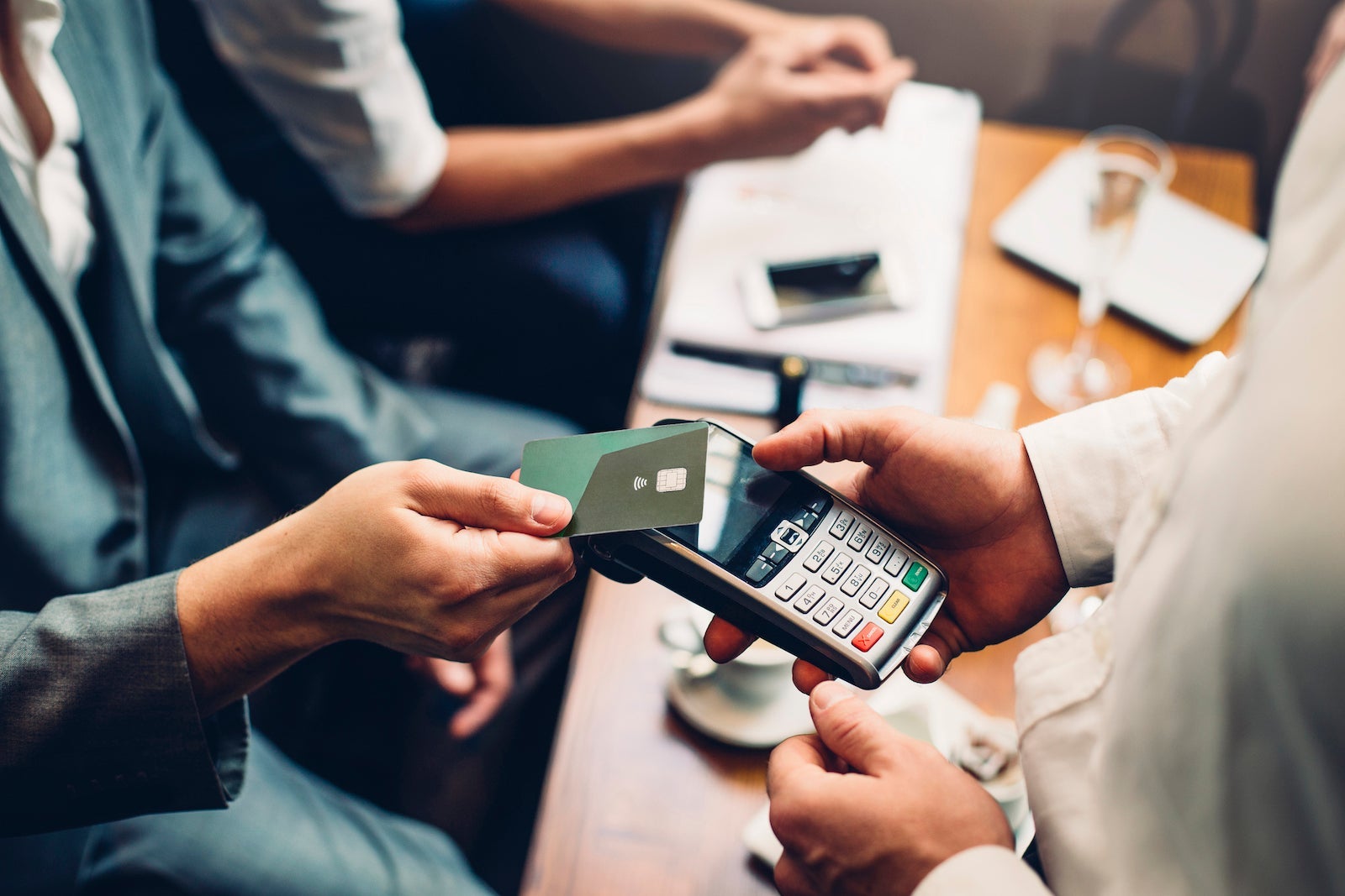 Close up of a card payment being made between a man and a waiter in a cafe.
