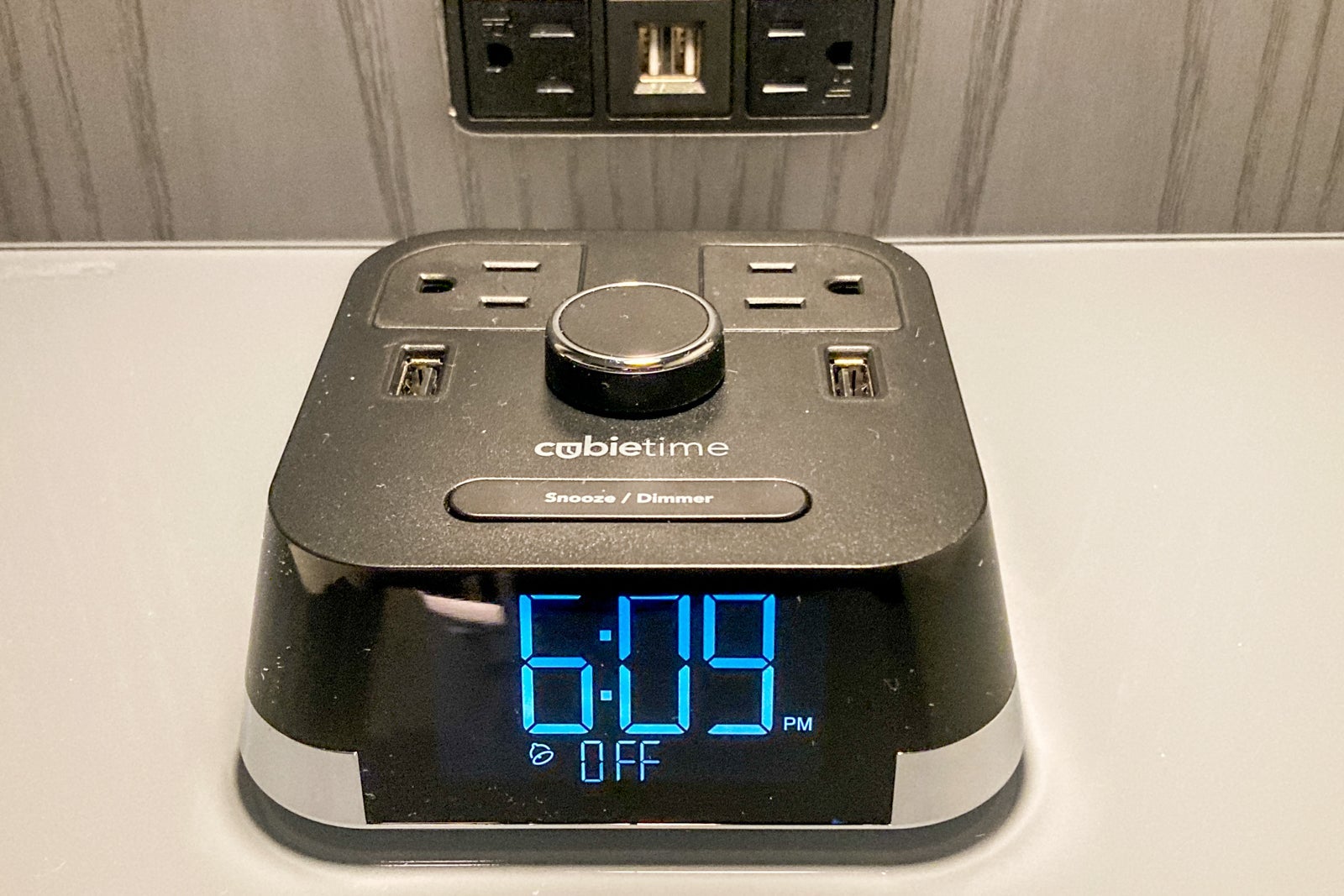 a digital clock with multiple plugs on it