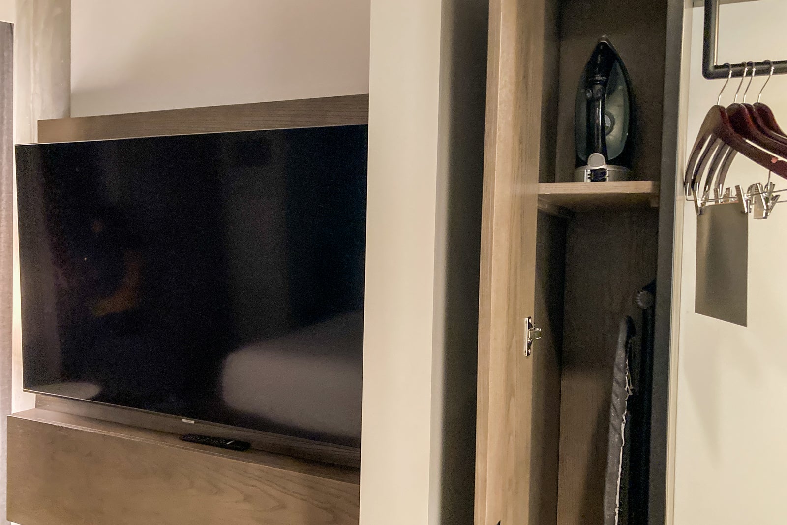 an open closet door shows an iron and ironing board inside