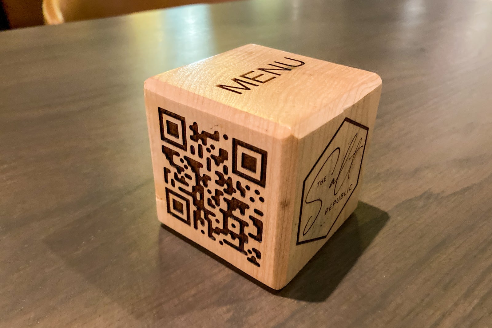 a wooden cube with a QR code for the menu