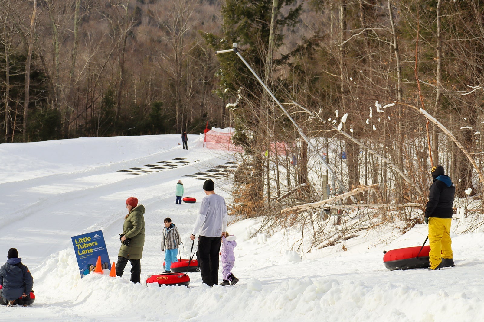 children snowtubing down a hill