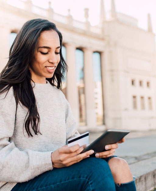 Woman holding a credit card and a tablet