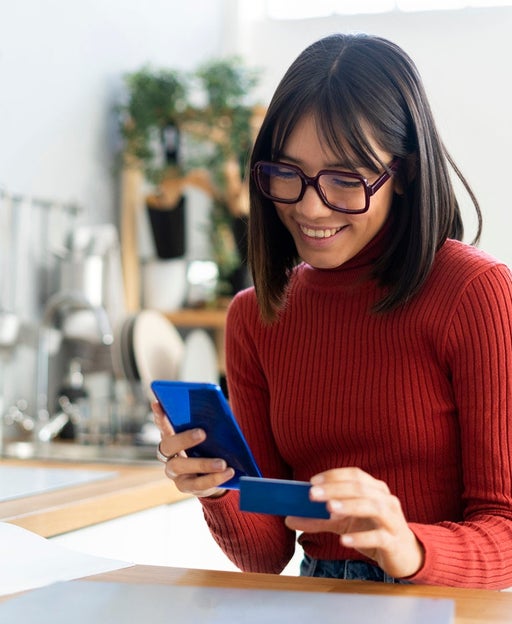 Woman holding her phone and a credit card
