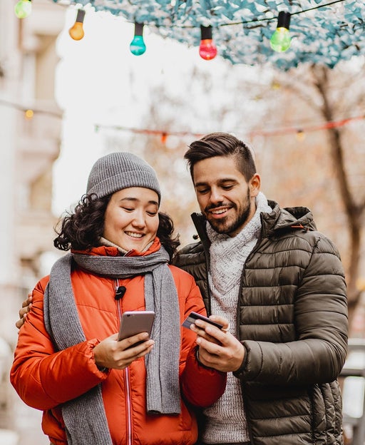 Young couple shopping online outdoors