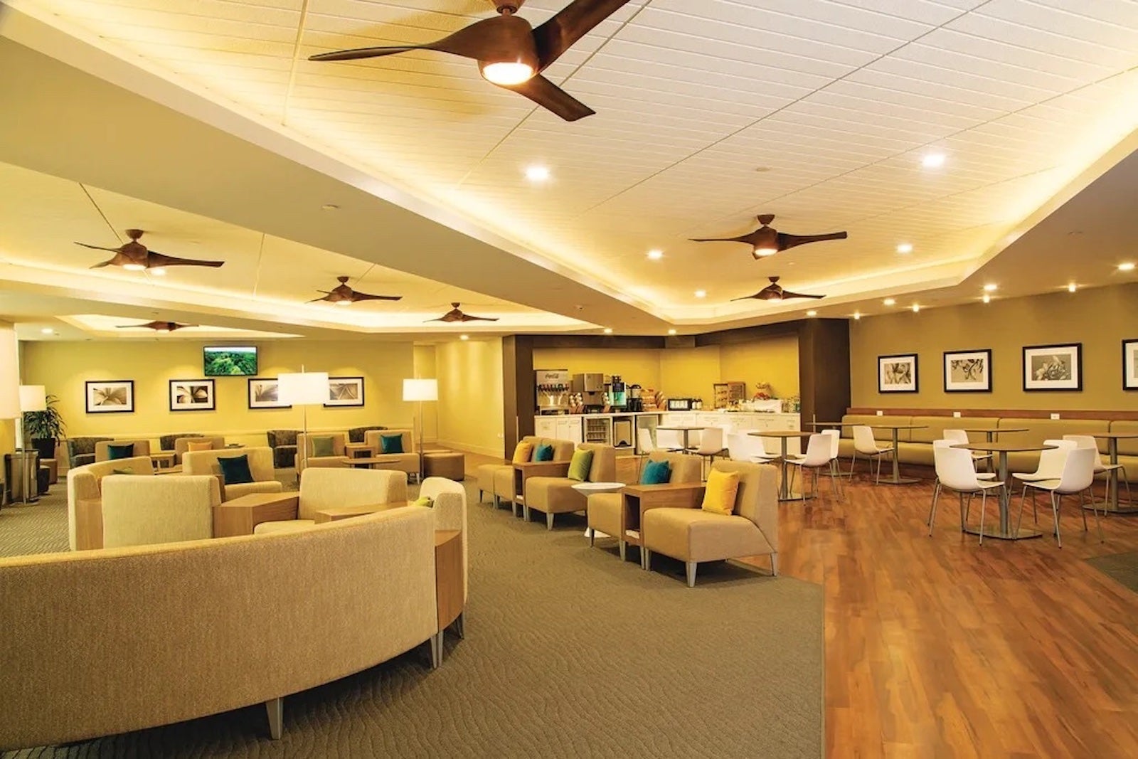 an open area inside an airport lounge, showing seating to one side and a walkway on the other