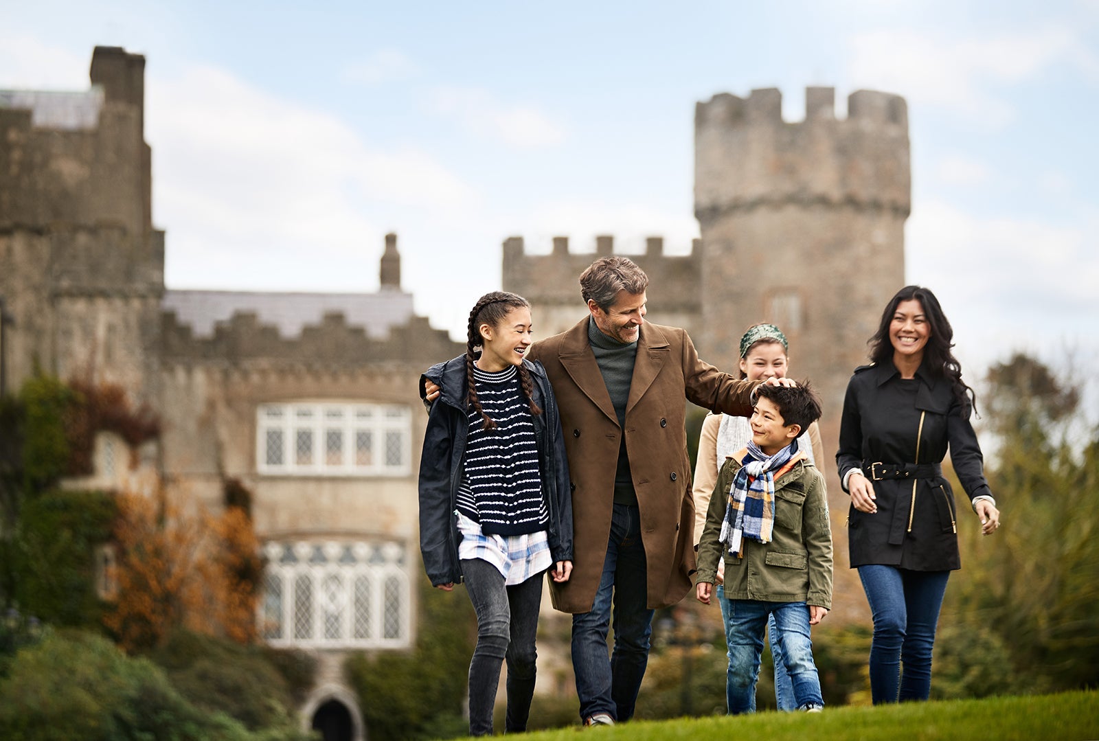 Family walking together with castle in Ireland in the background