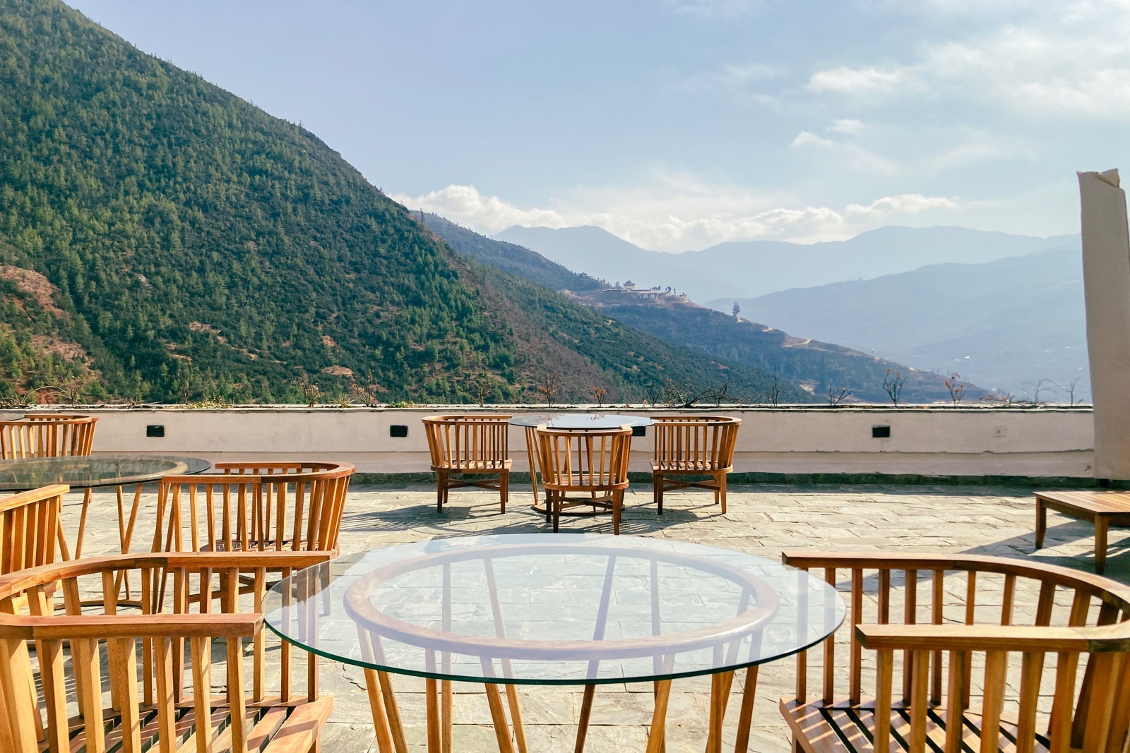 an outdoor terrace from a hotel restaurant, overlooking hills and a clear sky